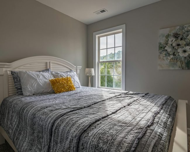 A warm, inviting bedroom with a double bed and natural light streaming in.